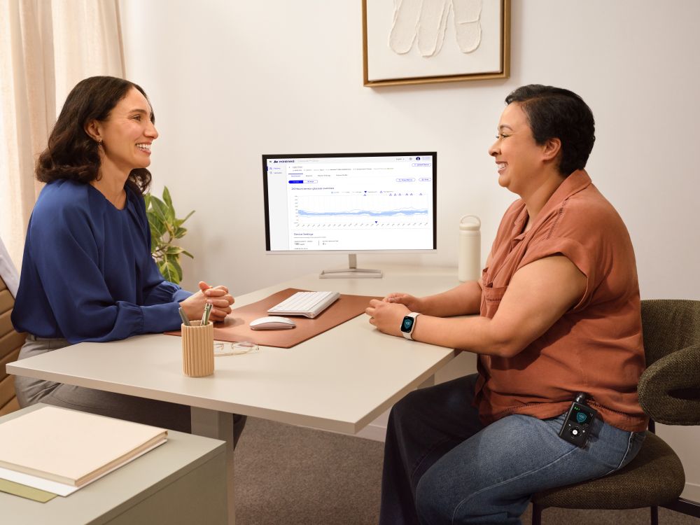Healthcare professional speaking with a patient wearing an insulin device